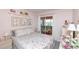 Cozy bedroom featuring floral bedding, pastel decor, and sliding glass doors to an enclosed porch at 4726 Marine Pkwy # 201, New Port Richey, FL 34652