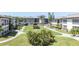 Landscaped community grounds, a well-maintained exterior with winding sidewalks, palm trees, and green grass at 4726 Marine Pkwy # 201, New Port Richey, FL 34652