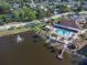 Aerial view showcases a community pool, clubhouse, lake with fountain, and private dock access at 4837 Prince George Cir, New Port Richey, FL 34655