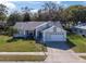 Front exterior view of a cozy home with attached garage and manicured landscaping at 4837 Prince George Cir, New Port Richey, FL 34655