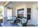 Inviting covered front porch with seating area perfect for enjoying the outdoors at 4837 Prince George Cir, New Port Richey, FL 34655