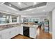 Well-lit kitchen with granite countertops, an island with a sink, and sleek appliances opens to living area at 4837 Prince George Cir, New Port Richey, FL 34655