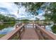 Picturesque lake view from a wooden dock, featuring a gazebo and serene waterfront living at 4837 Prince George Cir, New Port Richey, FL 34655