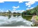 Scenic lake view reflecting the sky, trees, and adjacent homes creates a peaceful atmosphere at 4837 Prince George Cir, New Port Richey, FL 34655