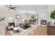 Inviting living room boasts hardwood floors, a ceiling fan, and transitions to a dining area for seamless entertaining at 4837 Prince George Cir, New Port Richey, FL 34655