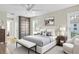 Well-lit main bedroom showcasing a large bed, bench, closet, and bedside tables at 4837 Prince George Cir, New Port Richey, FL 34655
