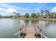 Scenic view from a wooden dock on the pond with seating and a glimpse of the community homes at 4837 Prince George Cir, New Port Richey, FL 34655