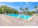 Large community pool with lounge chairs, a gazebo, and beautiful mature trees around the perimeter at 4837 Prince George Cir, New Port Richey, FL 34655
