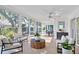 Sunroom with large windows showing backyard, tiled floors, overhead fan and patio furniture at 4837 Prince George Cir, New Port Richey, FL 34655