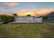 Backyard view of patio, lawn, and surrounding fence at sunset at 5106 Blue Heron Dr, New Port Richey, FL 34652