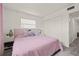 Light filled bedroom featuring a pink bed set, decorative pillows, and light gray wood flooring at 5106 Blue Heron Dr, New Port Richey, FL 34652