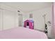 Cozy bedroom featuring pink bed, closet, a playhouse, and a desk with white trim at 5106 Blue Heron Dr, New Port Richey, FL 34652