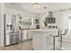 Modern kitchen features stainless steel appliances, an island with seating and wood look floors at 5106 Blue Heron Dr, New Port Richey, FL 34652