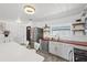 Well-lit kitchen with stainless steel appliances, white cabinets, and an island with seating at 5106 Blue Heron Dr, New Port Richey, FL 34652