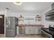 Modern kitchen with stainless steel appliances, wood countertops, and stylish open shelving at 5106 Blue Heron Dr, New Port Richey, FL 34652