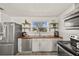 Bright kitchen with updated appliances, floating wood shelves, and eat in breakfast area at 5106 Blue Heron Dr, New Port Richey, FL 34652