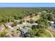 Aerial view of a home nestled among mature trees, golf course, and well-manicured lawns in a serene neighborhood at 5198 Legend Hills Ln, Brooksville, FL 34609