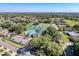 A beautiful aerial view of community amenities, including a pool, tennis courts, clubhouse, and ample parking at 5198 Legend Hills Ln, Brooksville, FL 34609