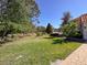 Expansive lawn with mature trees and landscaping, creating a serene and picturesque backyard setting at 5198 Legend Hills Ln, Brooksville, FL 34609