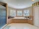 This bright bathroom offers a shower and large soaking tub surrounded by several windows at 5198 Legend Hills Ln, Brooksville, FL 34609