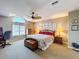 This primary bedroom features a ceiling fan, quaint decor, and lots of natural light at 5198 Legend Hills Ln, Brooksville, FL 34609