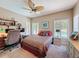 Bright bedroom with desk, ceiling fan and windows with backyard pool view at 5198 Legend Hills Ln, Brooksville, FL 34609