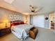 This primary bedroom features a ceiling fan, closet and view into primary bathroom at 5198 Legend Hills Ln, Brooksville, FL 34609