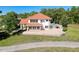 Stunning home featuring a red tile roof, large windows, and a spacious patio overlooking the pool at 5198 Legend Hills Ln, Brooksville, FL 34609