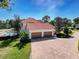 Aerial view of a home showcasing a three-car garage and well-manicured landscaping at 5198 Legend Hills Ln, Brooksville, FL 34609