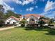 Stunning two-story house with a red tiled roof, lush lawn and mature landscaping at 5198 Legend Hills Ln, Brooksville, FL 34609