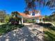 Gorgeous house with manicured lawn, mature trees and shrubs, plus a covered entry and tiled roof at 5198 Legend Hills Ln, Brooksville, FL 34609