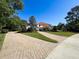 Charming home featuring a paver driveway, well-maintained landscaping, and a classic barrel tile roof at 5198 Legend Hills Ln, Brooksville, FL 34609
