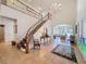 Grand foyer with staircase, chandelier, tile flooring, and an elegant view of the living room at 5198 Legend Hills Ln, Brooksville, FL 34609