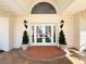 Inviting front entrance featuring double doors with decorative glass, decorative lighting and brick entryway at 5198 Legend Hills Ln, Brooksville, FL 34609