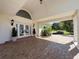 Welcoming front entrance with double glass doors, elegant lighting, and a covered porch at 5198 Legend Hills Ln, Brooksville, FL 34609