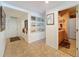 Hallway view of the bathroom entrance with tiled flooring and natural light at 5198 Legend Hills Ln, Brooksville, FL 34609