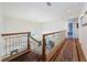 Upstairs hallway with iron railing overlooks the staircase and features a carpet runner at 5198 Legend Hills Ln, Brooksville, FL 34609