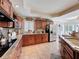 Gourmet kitchen with granite counters, stainless steel appliances, and custom wood cabinetry at 5198 Legend Hills Ln, Brooksville, FL 34609