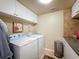 Bright laundry room features white washer and dryer, upper cabinets and neutral walls for a clean and functional space at 5198 Legend Hills Ln, Brooksville, FL 34609