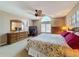 Bright main bedroom boasts a ceiling fan, an arched window and a mirrored dresser at 5198 Legend Hills Ln, Brooksville, FL 34609