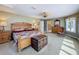 Tranquil main bedroom offers a comfortable bed, wooden furniture, and a connecting bathroom at 5198 Legend Hills Ln, Brooksville, FL 34609