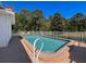 Inviting in-ground pool with brick trim, surrounded by a white fence and lush greenery at 5198 Legend Hills Ln, Brooksville, FL 34609