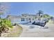Inviting single-story home with a lush landscaped yard, palm trees and long driveway at 5404 Quist Dr, Port Richey, FL 34668
