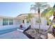 Charming home featuring a well-manicured yard with lush landscaping, palm trees and decorative rock at 5404 Quist Dr, Port Richey, FL 34668
