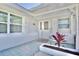 Charming front porch with a decorative door, white brick accents, and a well-maintained garden bed with a red plant at 5404 Quist Dr, Port Richey, FL 34668
