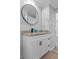 Bathroom vanity features marble countertop, modern fixtures, and stylish round mirror at 7252 Coventry Ct, Weeki Wachee, FL 34607
