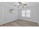 An empty bedroom with grey walls, a ceiling fan, a window with blinds and laminate floors at 7252 Coventry Ct, Weeki Wachee, FL 34607