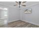 An empty bedroom with grey walls, a ceiling fan, a window with blinds and laminate floors at 7252 Coventry Ct, Weeki Wachee, FL 34607