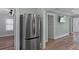 Hallway features a stainless steel refrigerator and leads to rooms with a consistent flooring and wall color scheme at 7252 Coventry Ct, Weeki Wachee, FL 34607