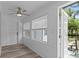 Bright sunroom features white wood paneling, ceiling fan, and outdoor access to the waterfront deck at 7252 Coventry Ct, Weeki Wachee, FL 34607